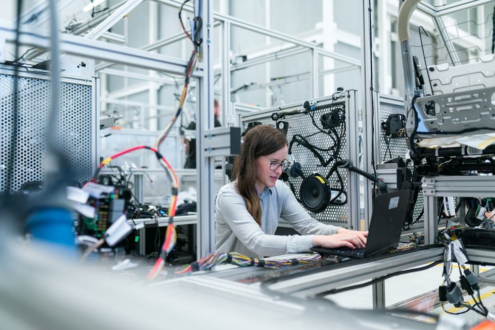 Engineer working at a laptop on a test rig in a factory